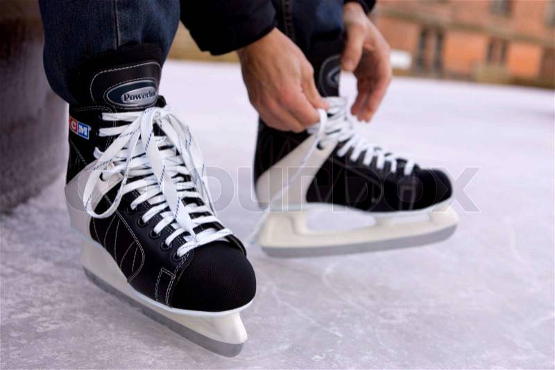 Cropped image of a person tying ice skates, stock photo