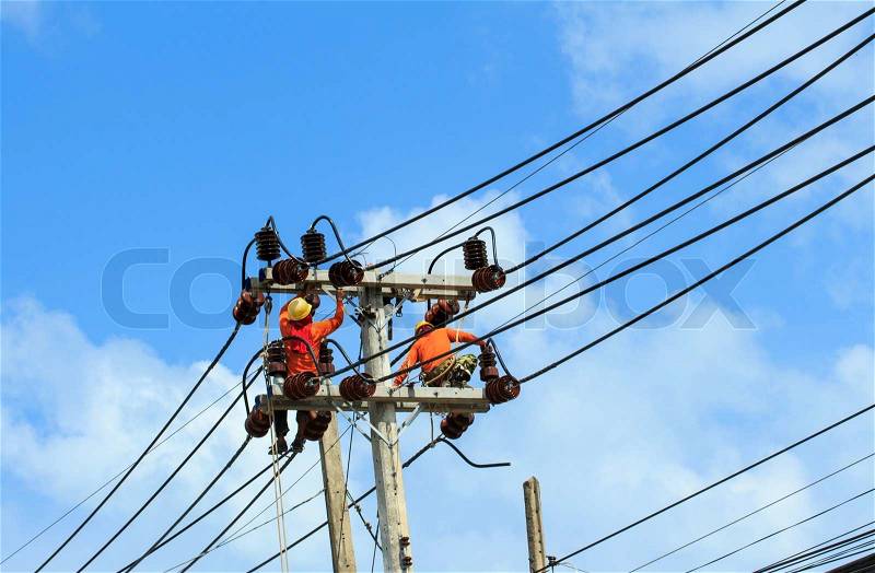 An electrical power utility worker fixes the power line, stock photo