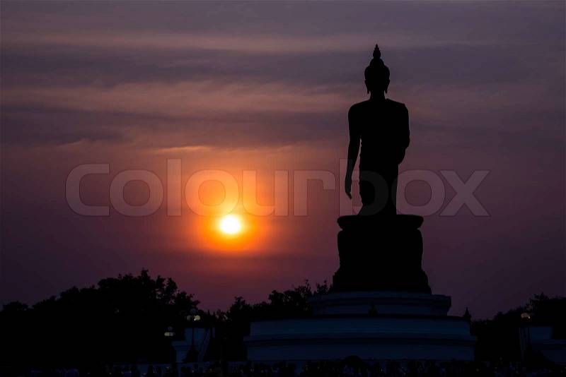 Statue of buddha at sunset silhouette, stock photo