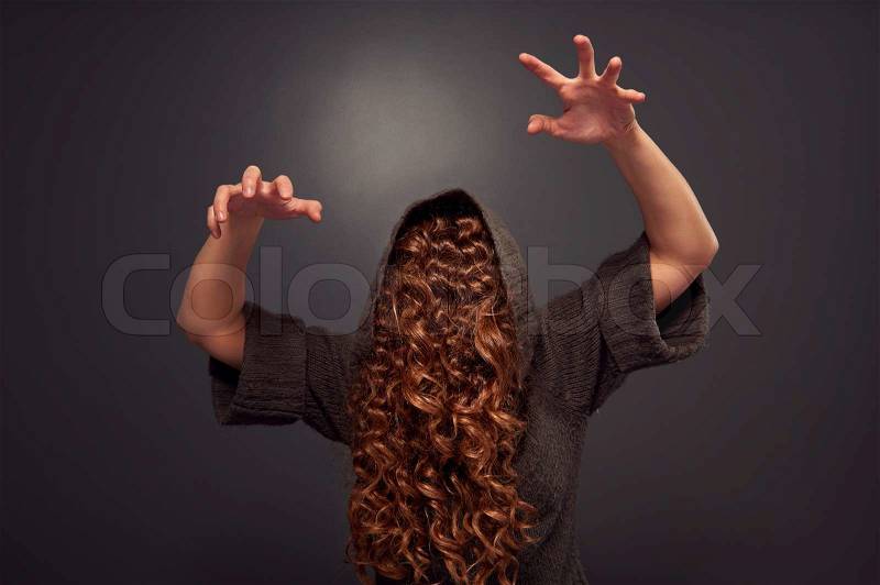 Hairy woman frightening over dark background, stock photo