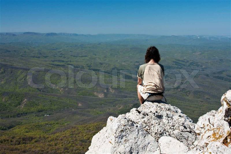 In harmony with nature - man meditating in the mountains, stock photo