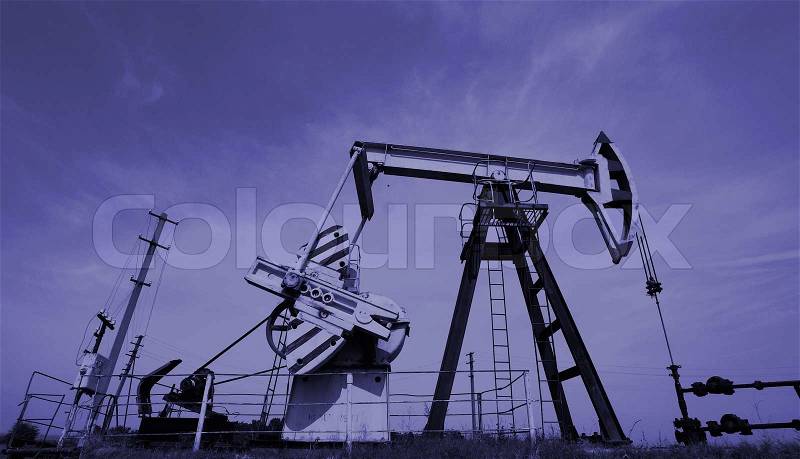 Extraction of oil. Pump jack and oil wellhead. Toned. , stock photo