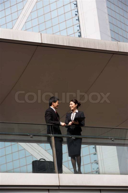 Two Business Colleagues Having Discussion Outside Office Building, stock photo