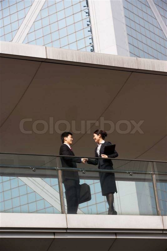Two Business Colleagues Shaking Hands Outside Office Building, stock photo