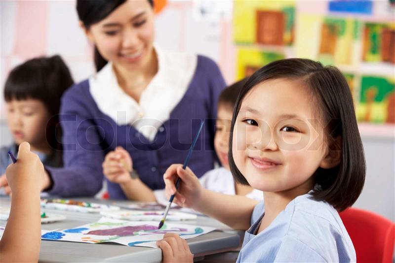 Female Pupil Enjoying Art Class In Chinese School Classroom, stock photo