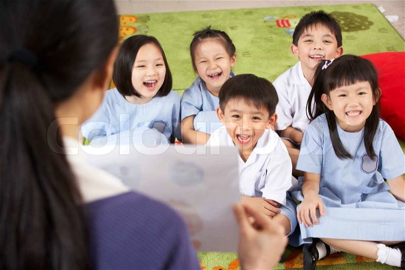 Teacher Showing Painting To Students In Chinese School Classroom, stock photo