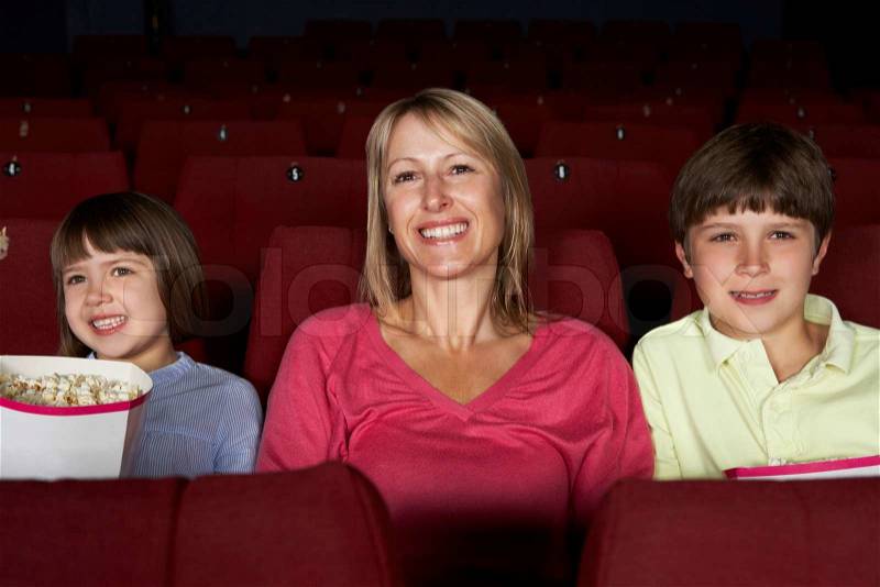 Mother Watching Film In Cinema With Two Children, stock photo