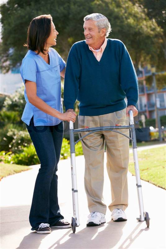 Carer Helping Senior Man With Walking Frame, stock photo