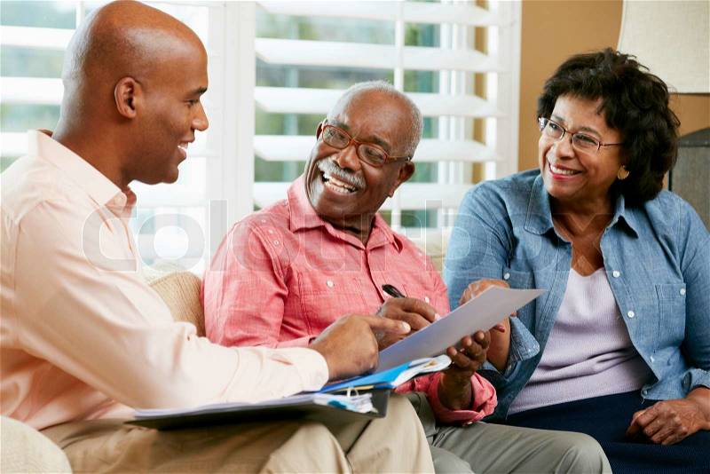 Financial Advisor Talking To Senior Couple At Home, stock photo