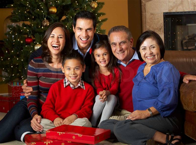 Multi Generation Family In Front Of Christmas Tree, stock photo