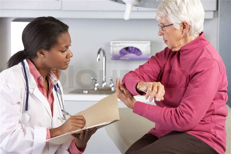 Doctor Examining Female Patient With Elbow Pain, stock photo