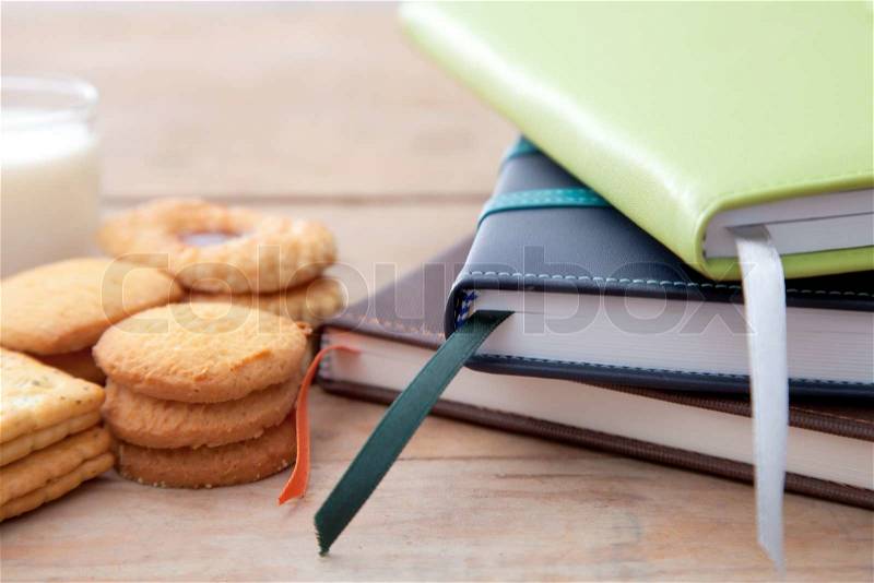 Notebook stack and some dessert on table, stock photo