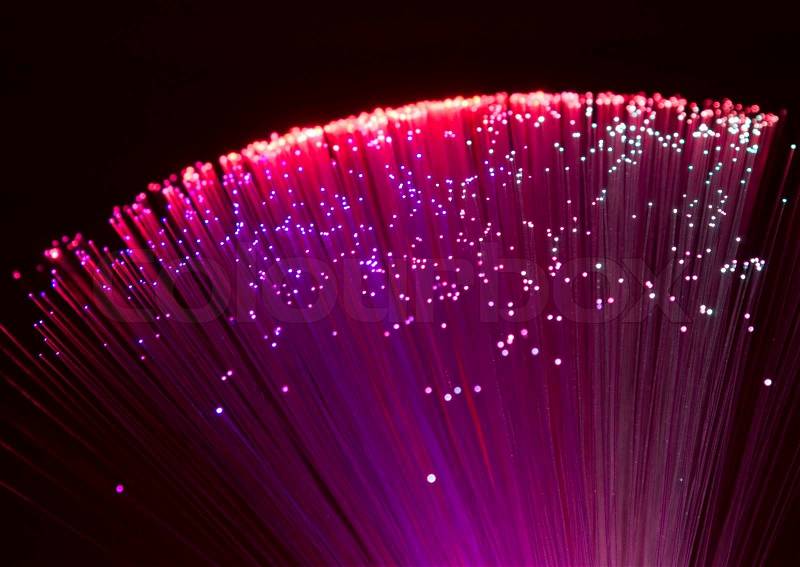 Colorful illuminated plastic optical fibers in dark back, stock photo
