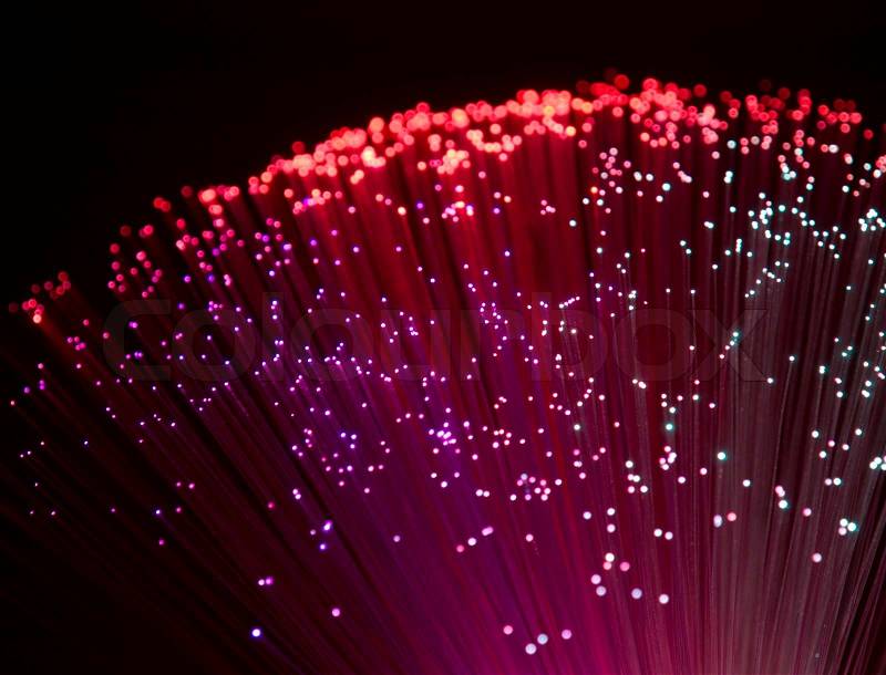 Colorful illuminated plastic optical fibers in dark back, stock photo