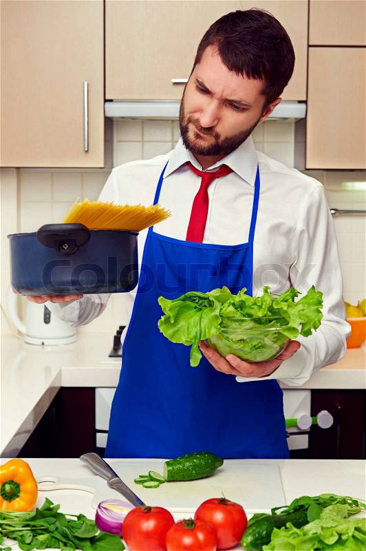 Man holding lettuce and pan with spaghetti, stock photo