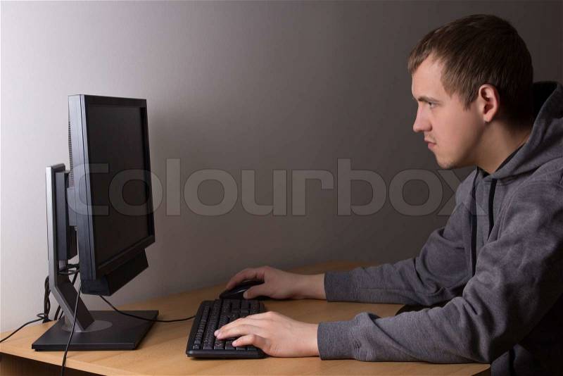Young man using a computer at home, stock photo