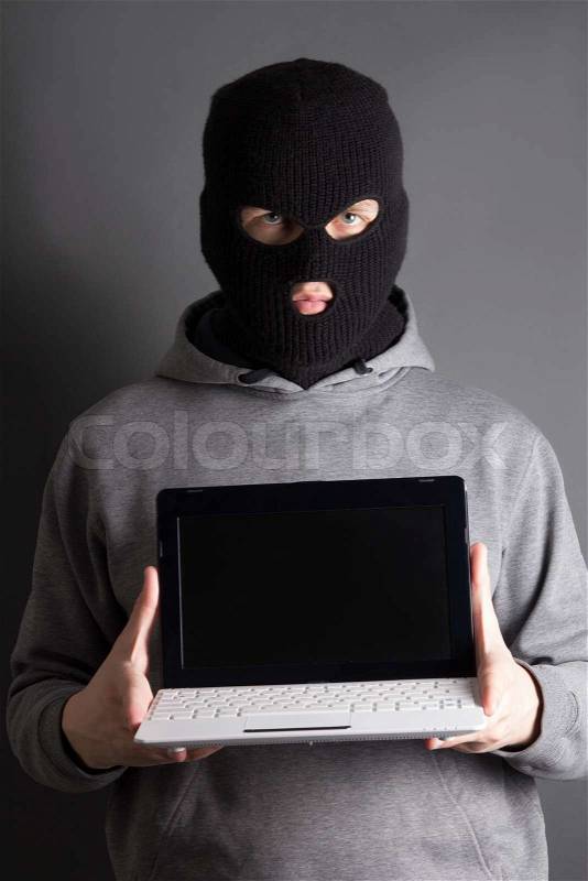 Masked man with computer over grey, stock photo