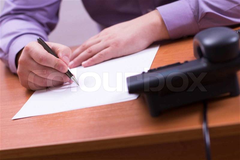 Businessman sitting at office desk and plans its work, stock photo