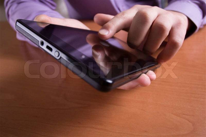 A man holds up and running on a Tablet PC, stock photo