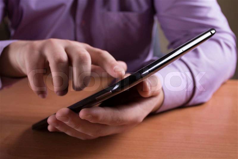 A man holds up and running on a Tablet PC, stock photo