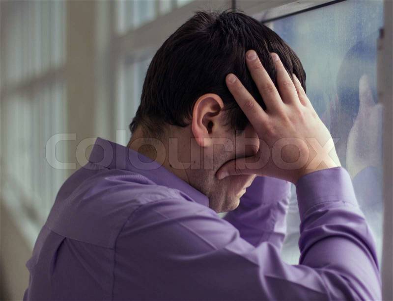 A man holds his head, hi have big problems, stress, stock photo