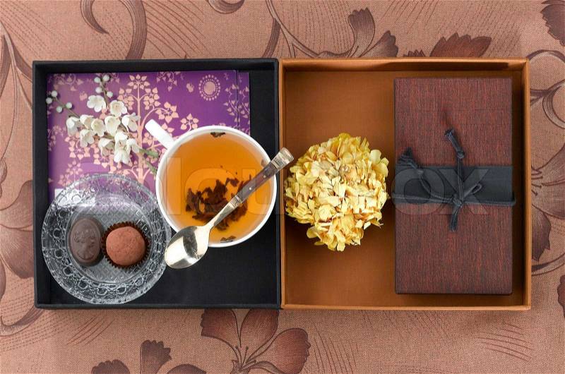 Cup of tea decoration and display box on brown fabric background , stock photo