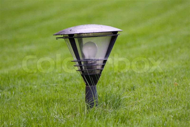 Street lamp on the green grass, stock photo