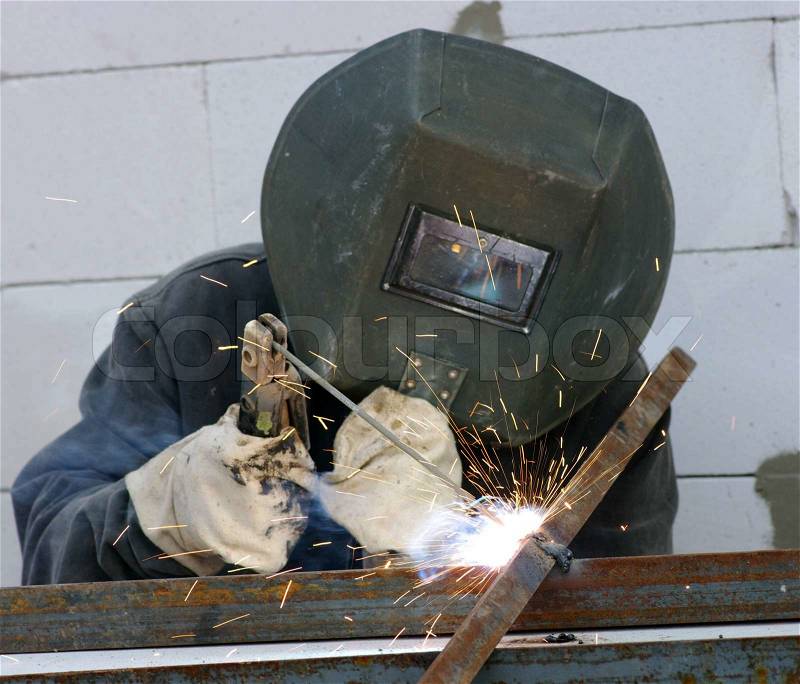Welder worker welding metal. Bright electric arc and sparks , stock photo