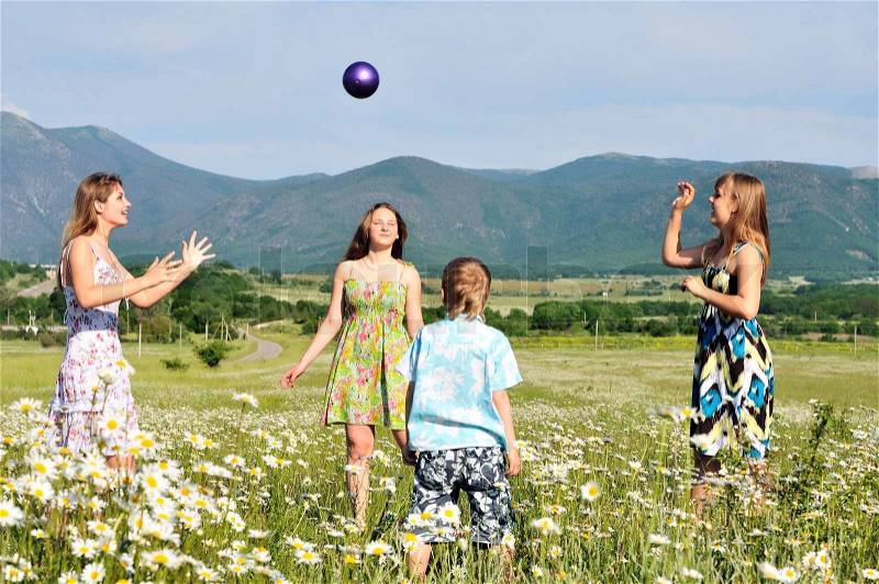 Boy and teen girls playing a ball in field , stock photo