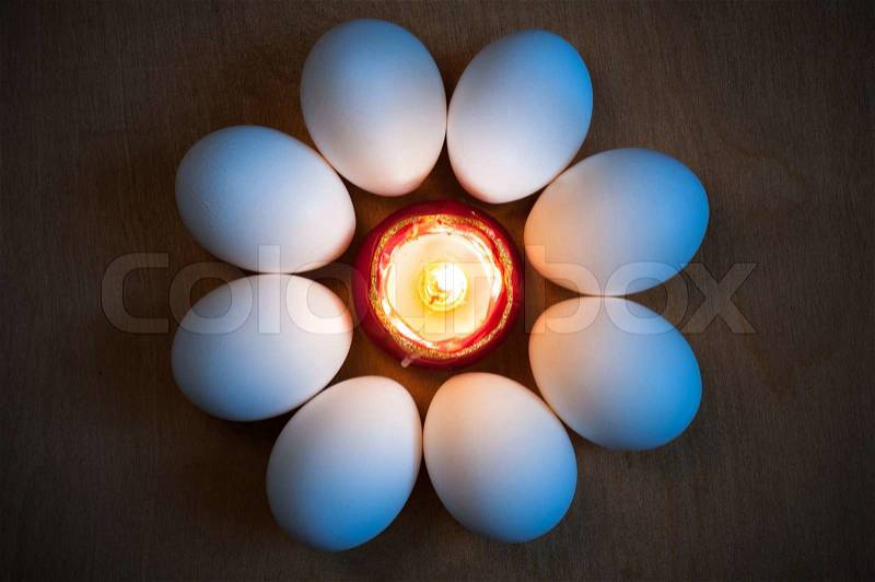 Easter eggs are laid around the candle in the form of a flower, stock photo