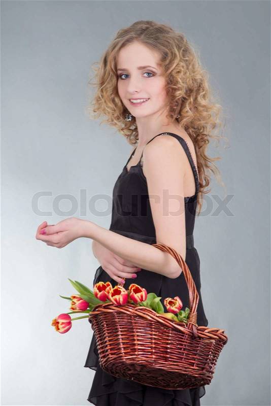 Young woman with basket of flowers, stock photo