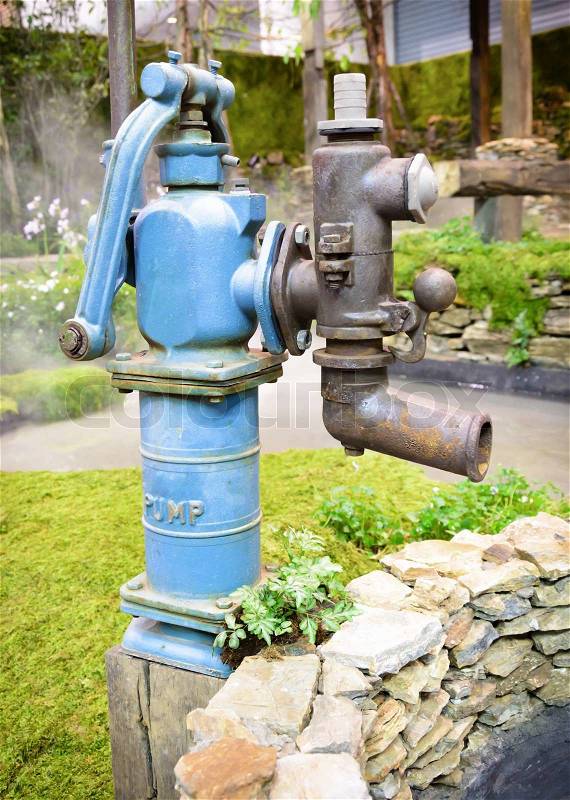 Old retro water pump in garden, stock photo