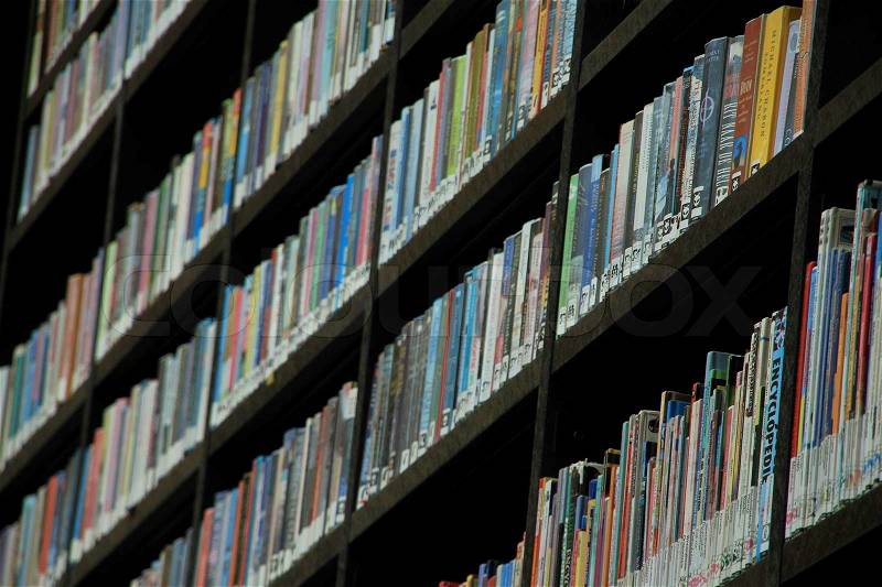 Bookcase with all kind of books in different colours in order to hire in the municipal library, stock photo