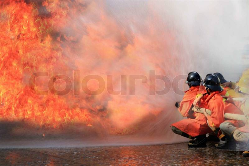 Firefighters fighting fire during training, stock photo