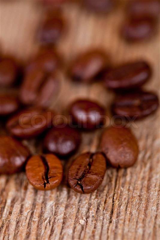 Fresh coffee beans on rustic wooden board macro image, stock photo