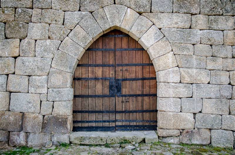 Old medieval castle gate in a fortified granite wall, stock photo