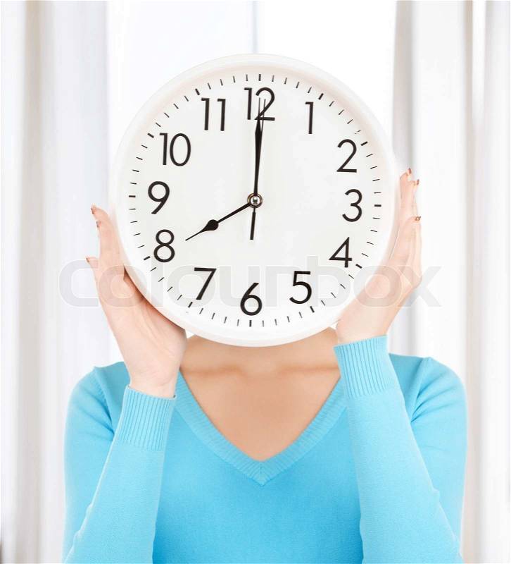 Businesswoman with clock over her face, stock photo