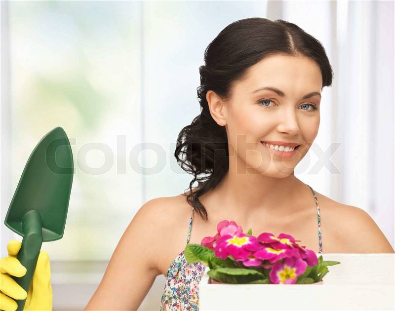 Lovely housewife with flower in box and gardening trowel, stock photo