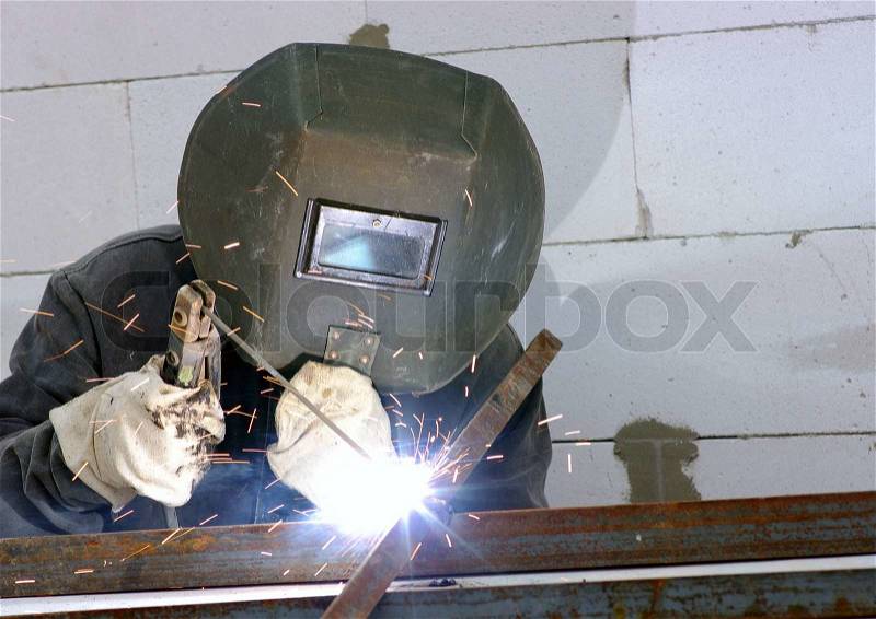 Welder worker welding metal. Bright electric arc and sparks , stock photo