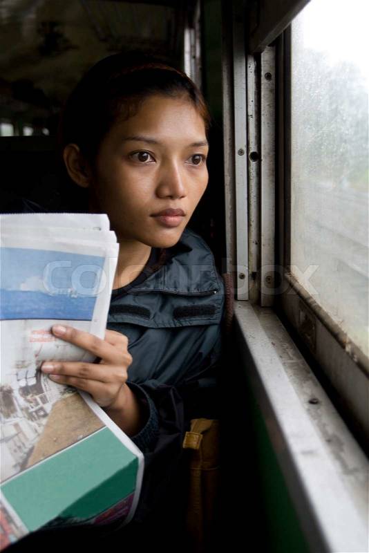 Young woman reading a newspaper on a train , stock photo