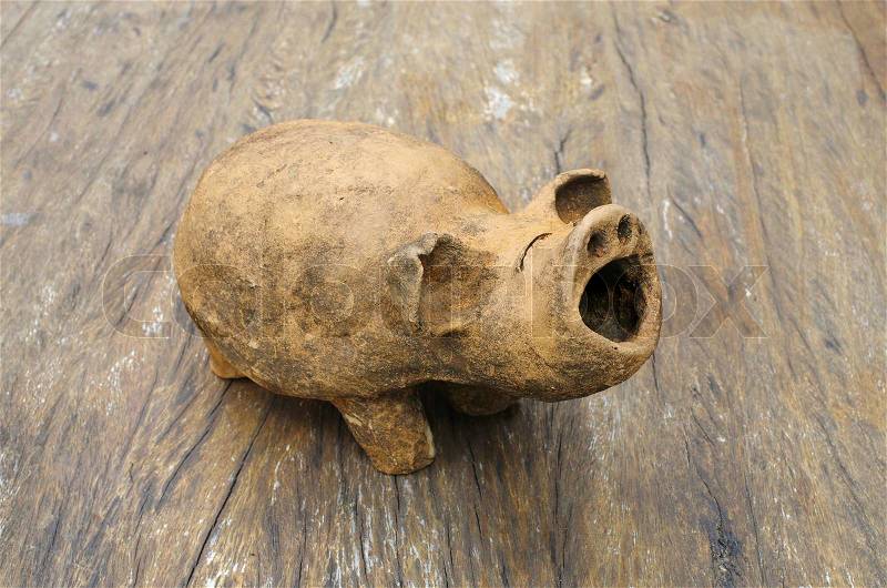 Baked-clay pig on wood table, Thailand, stock photo