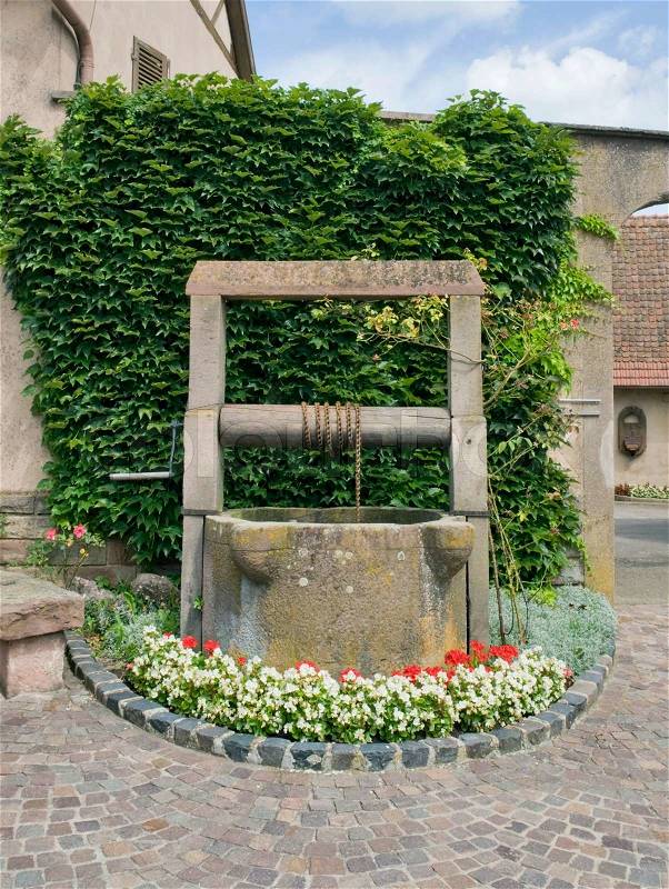 Historic draw well in Mittelbergheim, a village of a region in France named Alsace, stock photo
