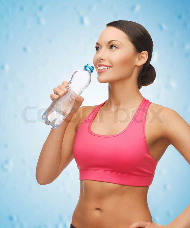Picture of sporty woman drinking water from bottle, stock photo