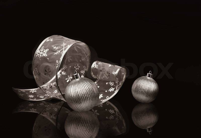Sepia toned silver ribbon and Christmas balls on dark background, stock photo