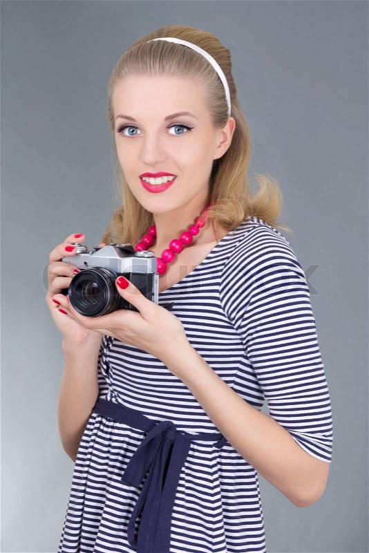 Young woman in retro clothes posing with old photo camera, stock photo