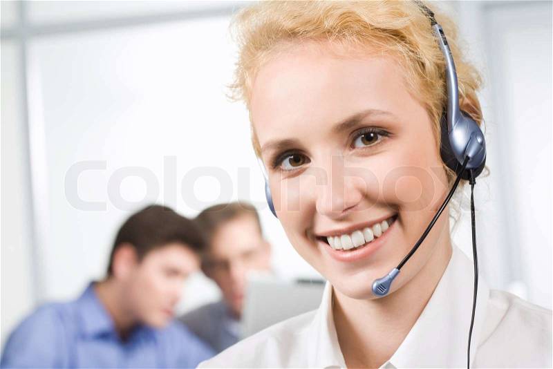 Portrait of responsible operator on the background of two co-workers, stock photo