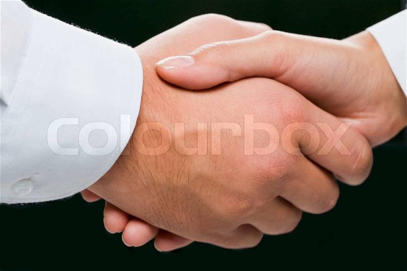 Close-up of shaking hands on the black background, stock photo