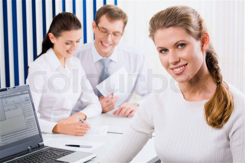Portrait of intellectual woman in white clothes on the background of two colleagues, stock photo