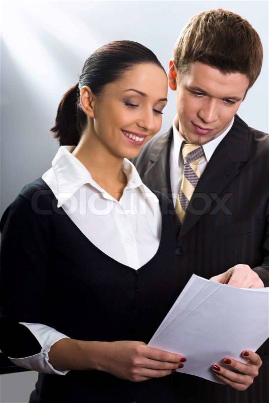 Man and woman in the suits examine the documents, stock photo