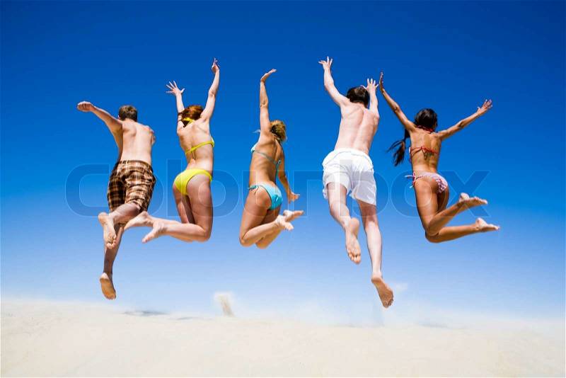 Portrait of jumping young people a backs on the beach , stock photo